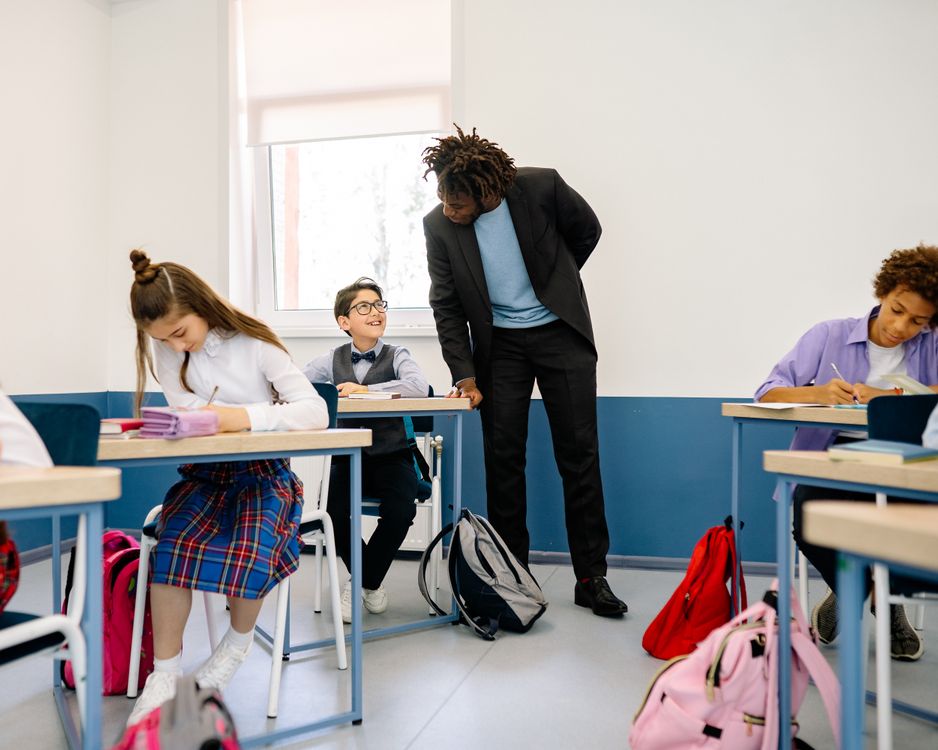 A teacher supporting pupils as they work in a classroom
